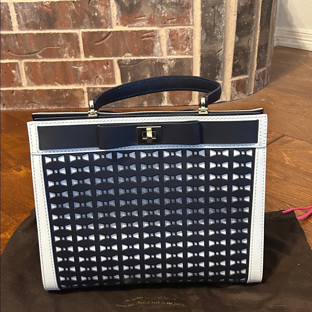 Kate Spade Navy & Cream Leather Top Handle Bag with Metal Clasps and Pockets.